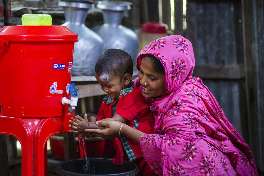 Rinku, 25, helps her son wash his hands with soap 
