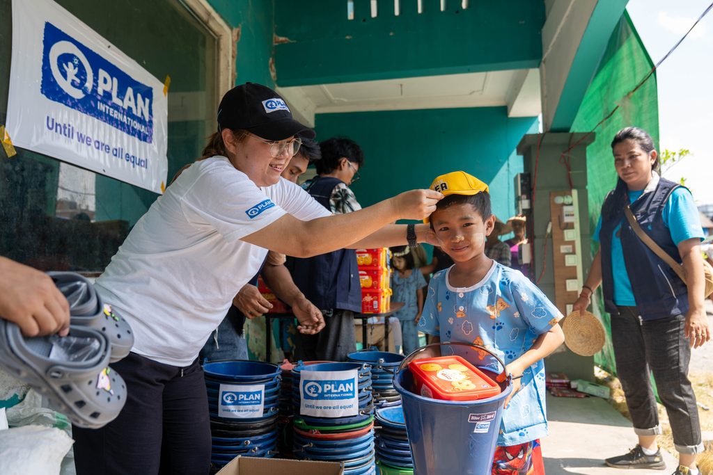 A boy collects items at a resettlement site.
