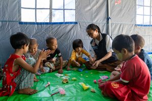 Children clap and play in a child-friendly space.