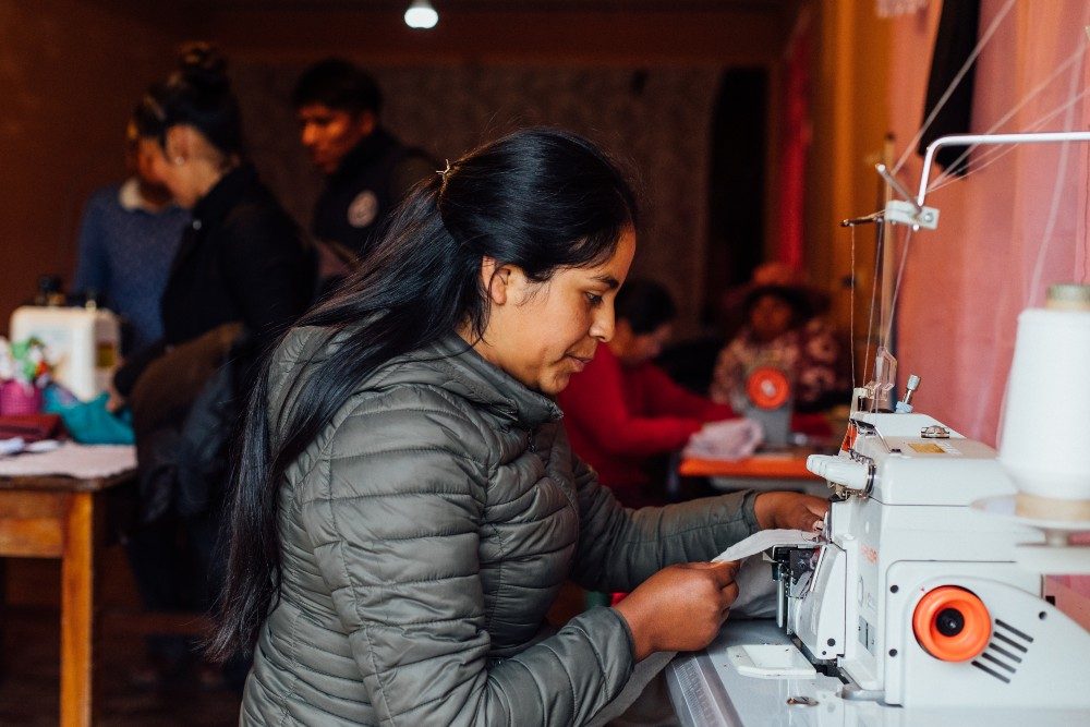 Erlinda using her sewing machine to make clothing