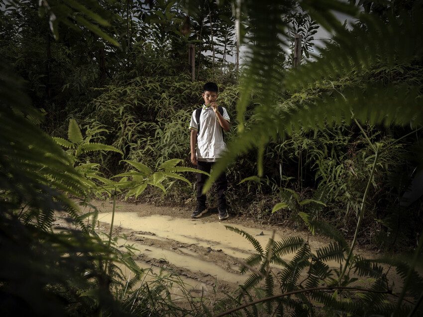 Brayan standing next to a road with puddles