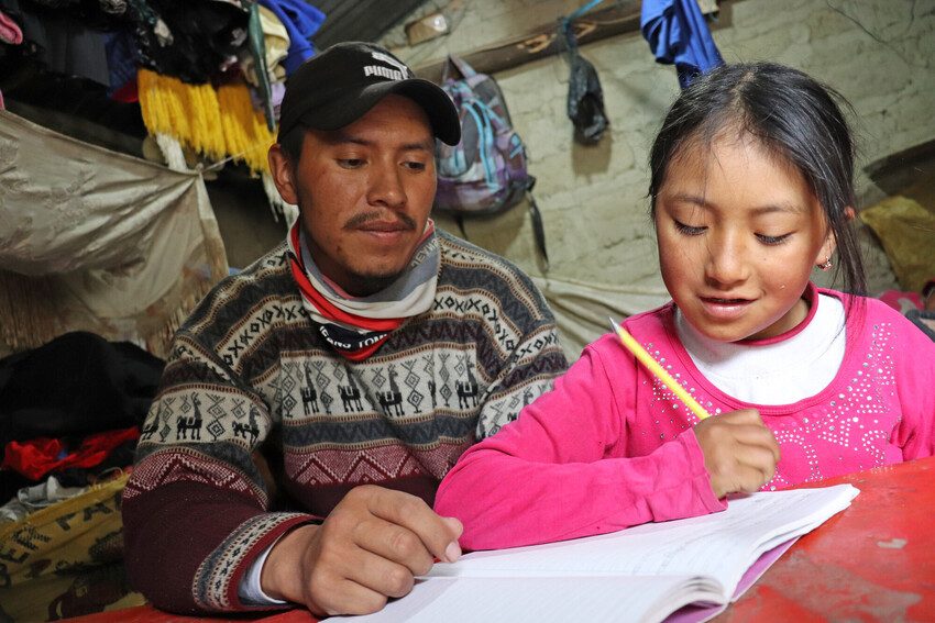 Father helps daughter with schoolwork.  