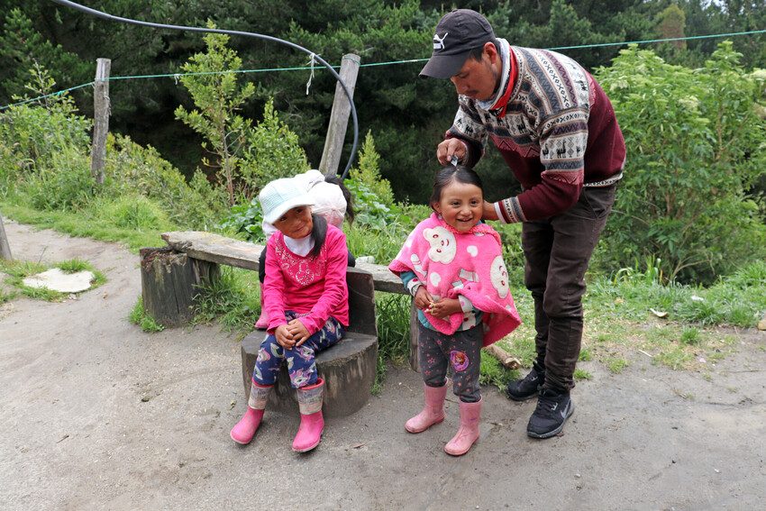 Father getting his daughters ready for school.