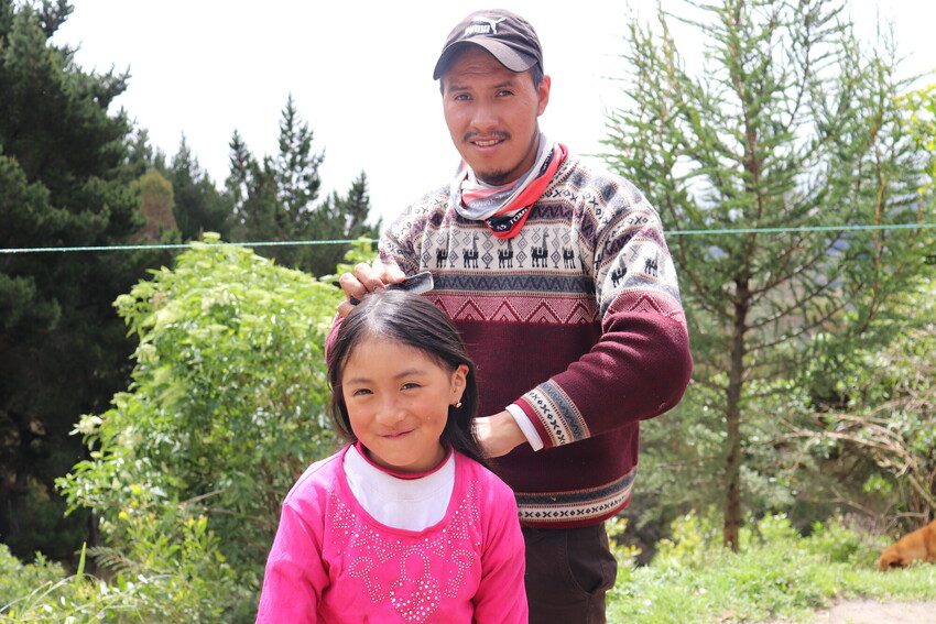 Father brushes his daughter's hair.