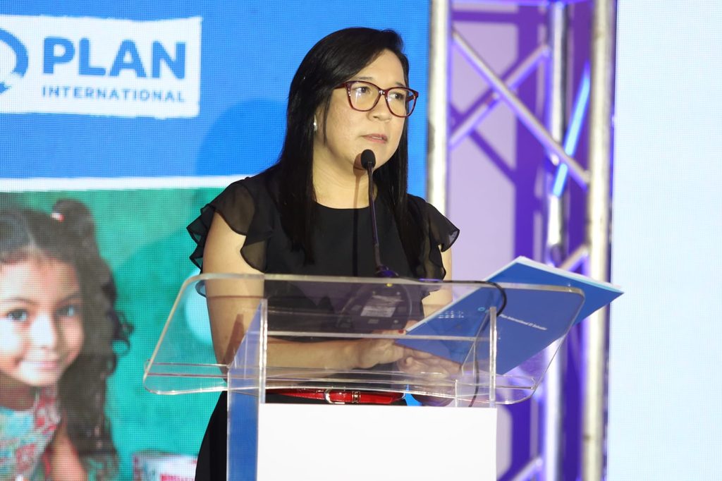 Directora en funciones de Plan International El Salvador da discurso en evento de celebración por cumplir 45 años en El Salvador.