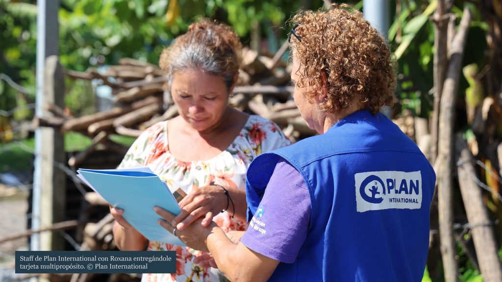 Staff de Plan International con Roxana entregándole tarjeta multipropósito