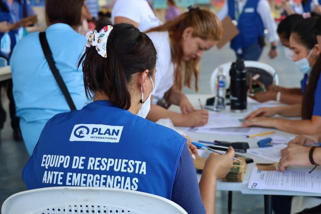 Equipo de acción humanitaria entregando tarjetas multipropósito a las familias afectadas por las tormentas. © Plan International