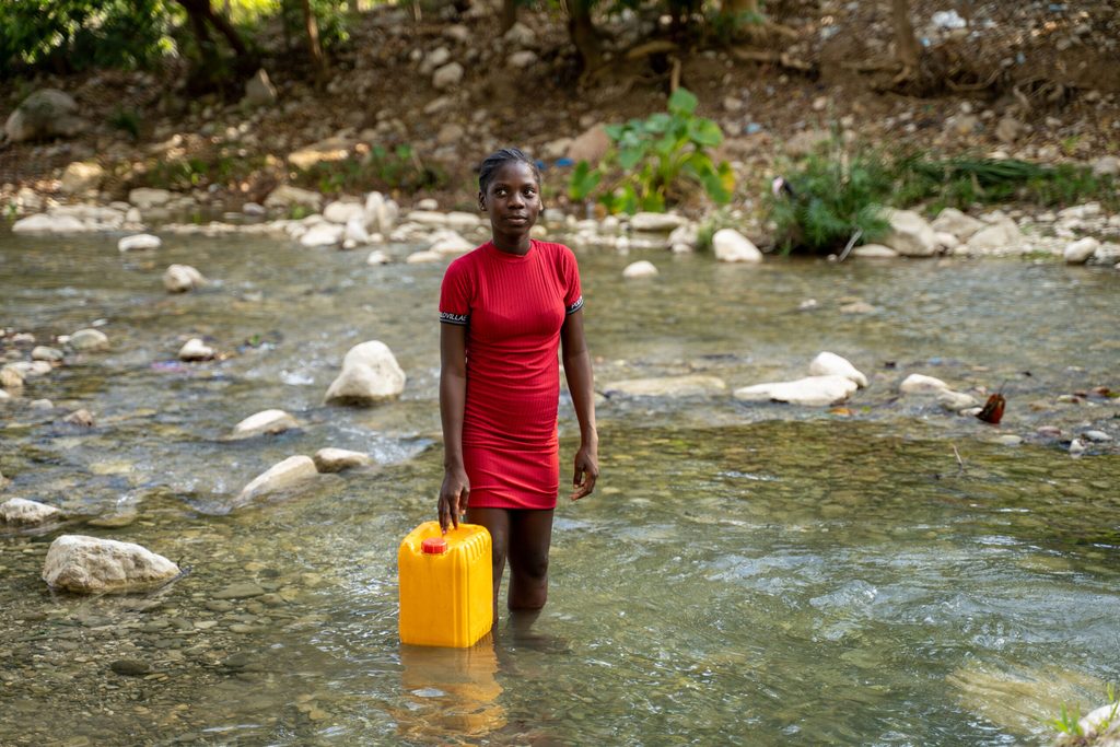 Sofiana, 13, gets water from the river.