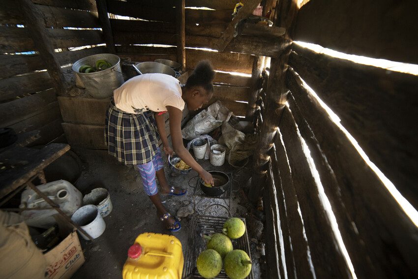Barbara*, 13, prepares meal at her home in Haiti