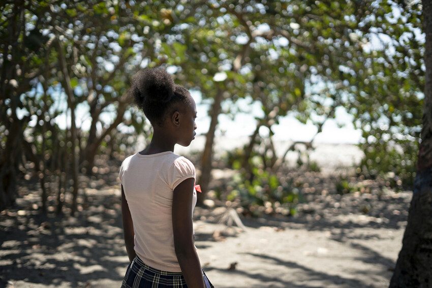 Barbara*, 13, looking away from the camera in her community in Haiti