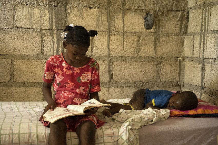Lettycia reads at her home in the South East of Haiti