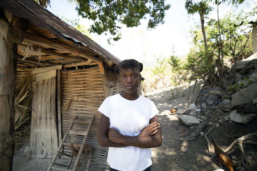 Dialissa, 15, outside her home in Haiti