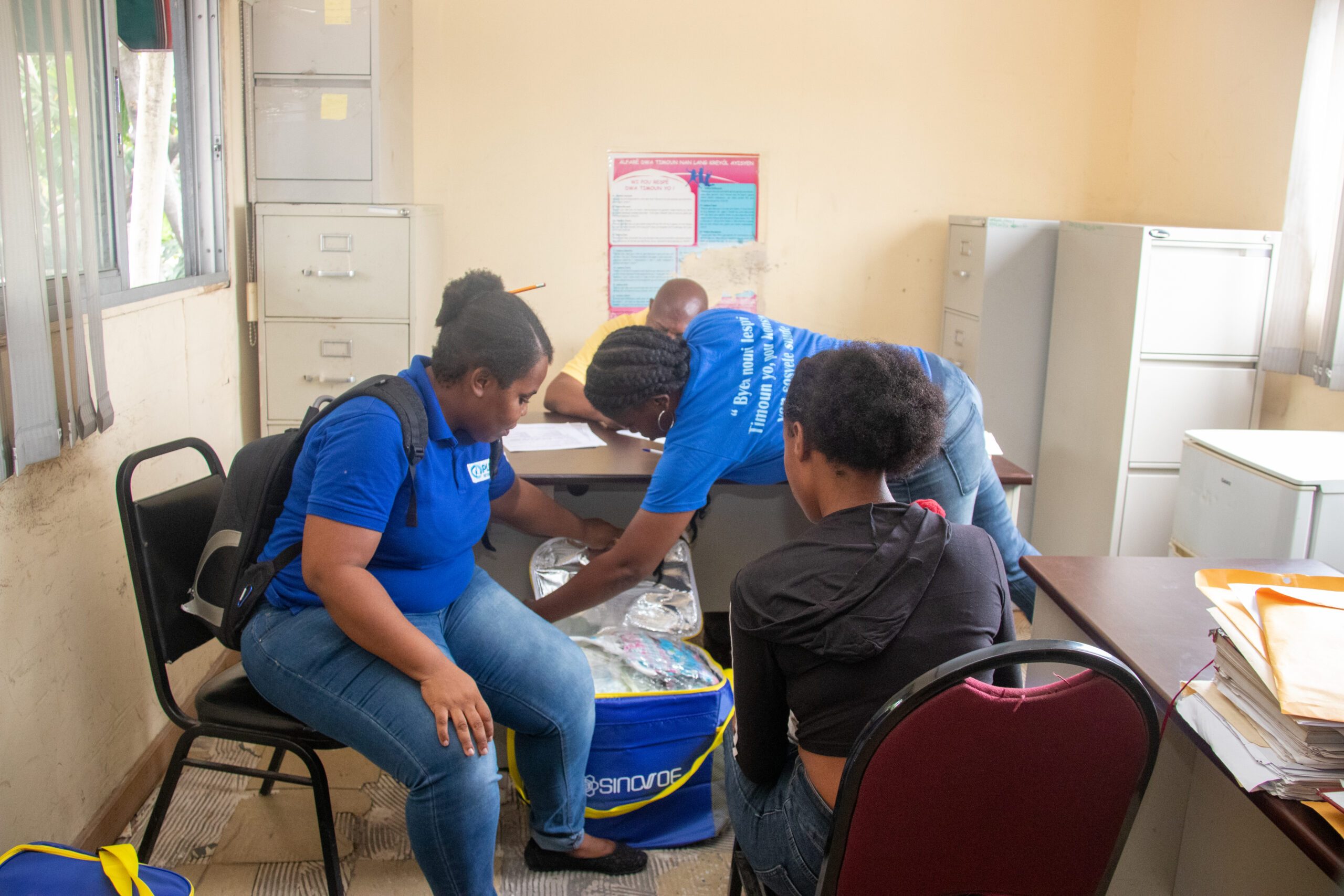 Nathalie, 17  receiving food and hygiene kit from Plan at institute for Social Wellbeing and Research office