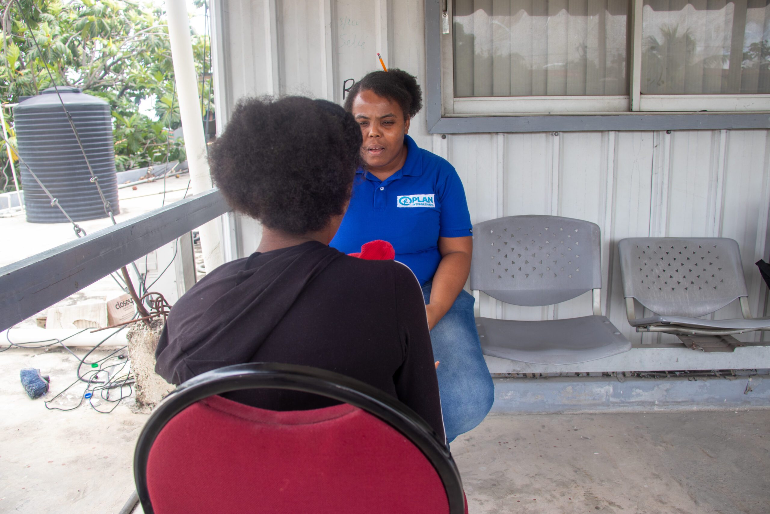 Nathalie, 17 and her 6-year-old daughter, with a Plan staff. 