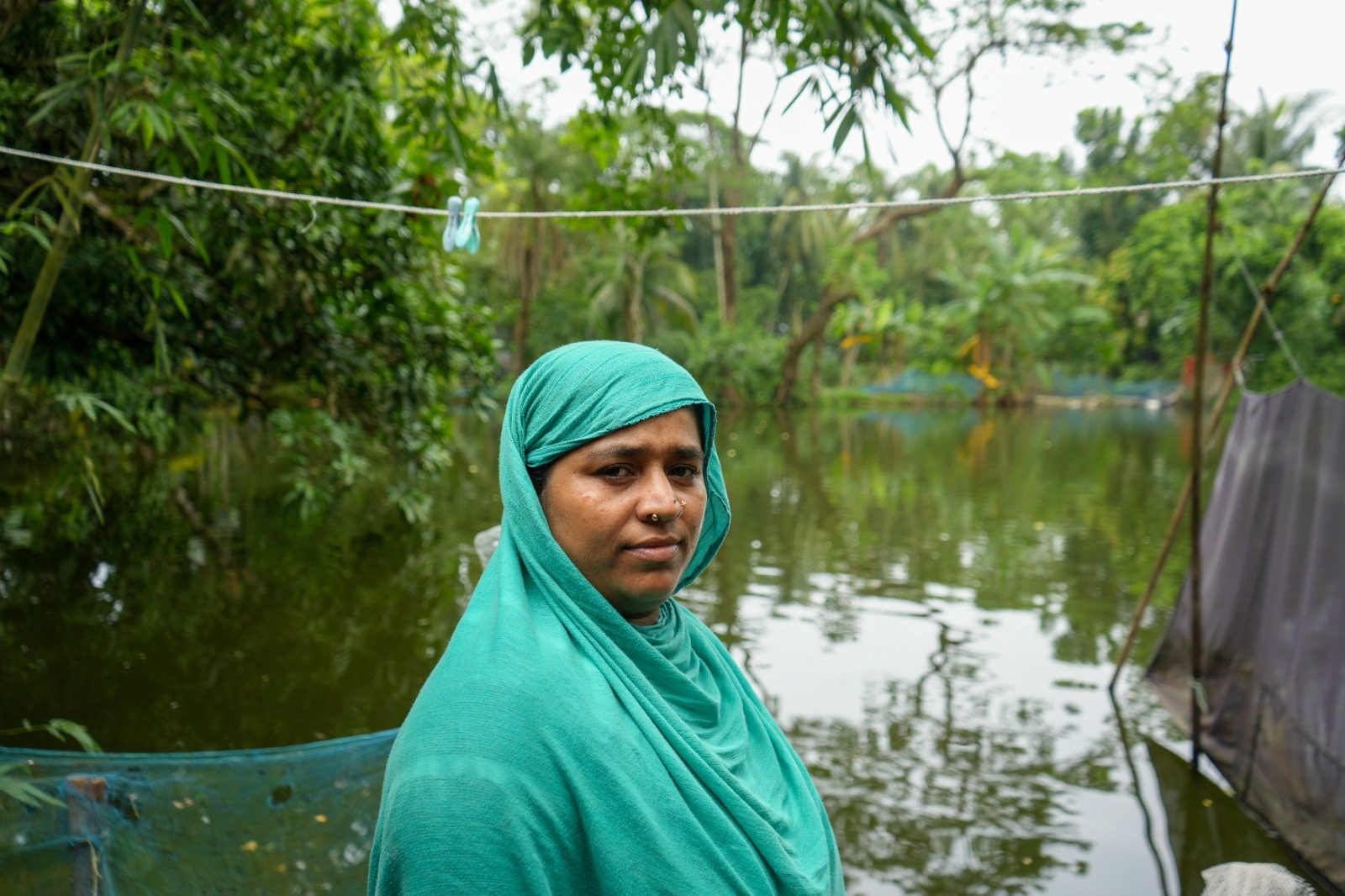 Sahanur stands in front of a lake.