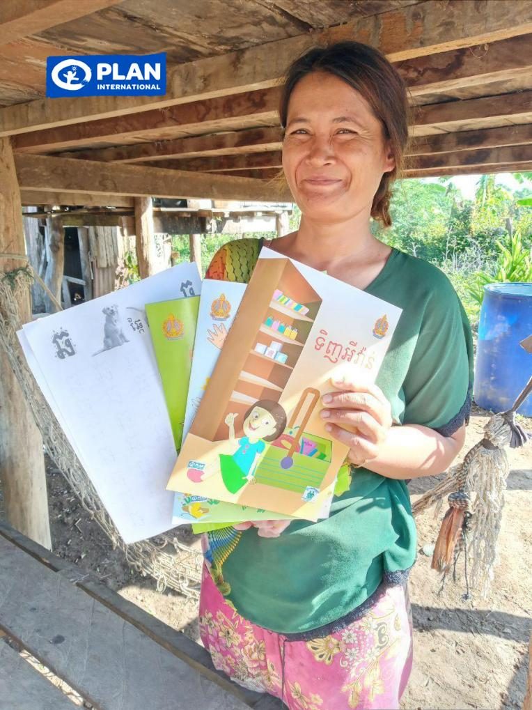 Mrs. Mangnoy holding books used to teach her children at home.