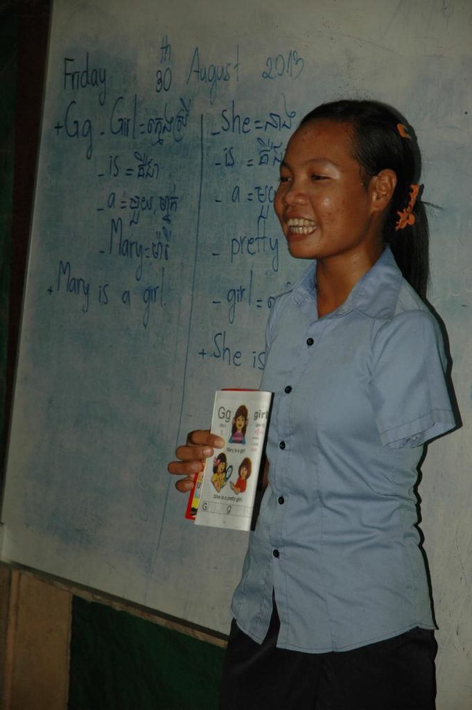 Tot teaching English to young children in her community.