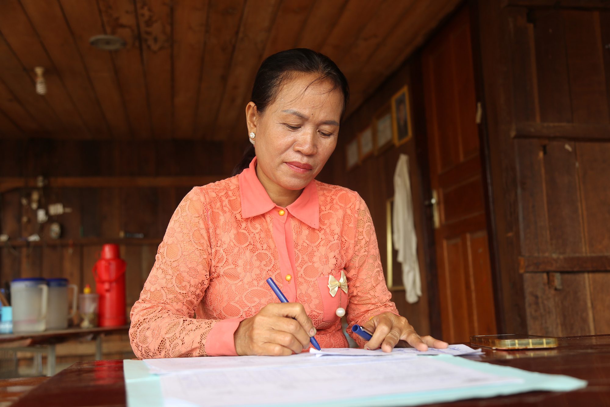 Thak is writing at her desk. 