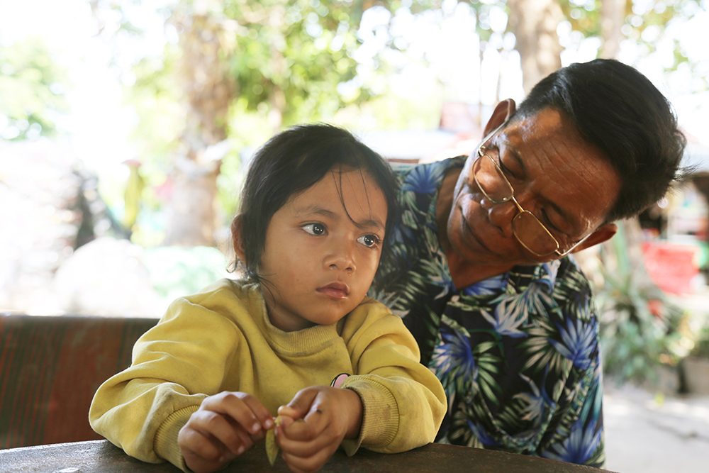 Phat and his granddaughter at home.  