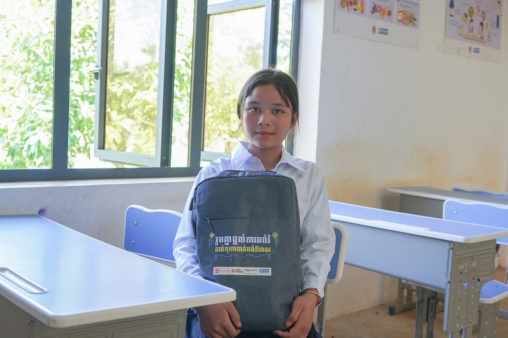 Yung is sitting in the classroom with her new school bag.