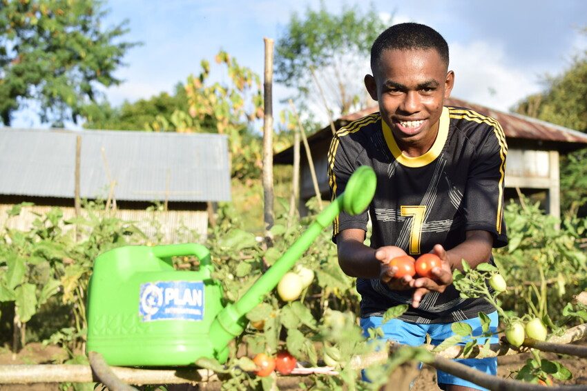 Paul, 20, with the tomatoes he has grown in his garden in Lembata Island, Indonesia