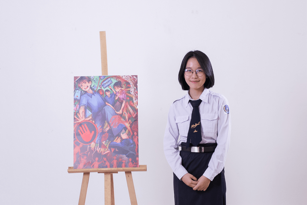 Vannapha standing and smiling with her master artwork.