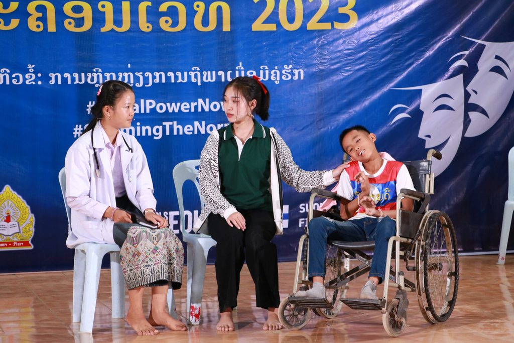 Chanpheng and her peers perform a drama on the stage.