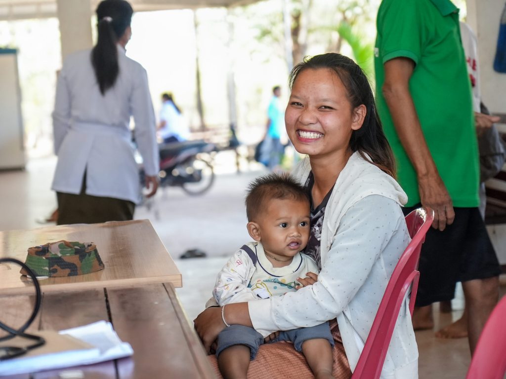 image of khamkeo holding her child waiting for health services at health centre Khamkeo holding her son and waiting for the doctor.