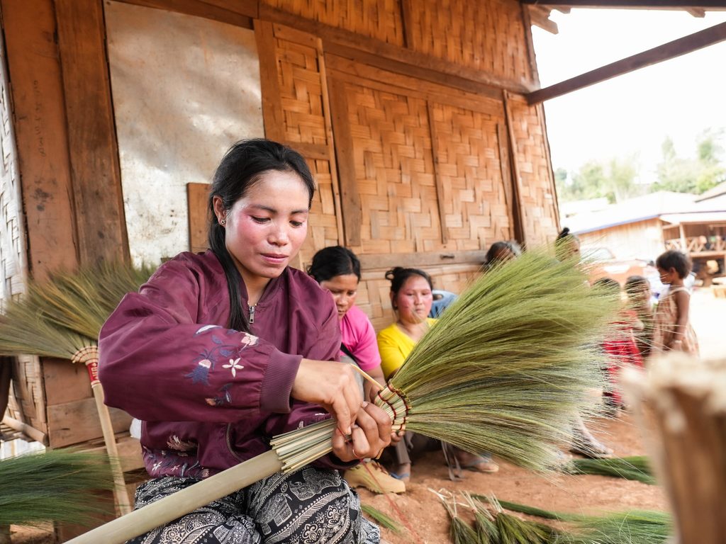 Image of Jan weaves a broom from flowers of broom grass Jan demonstrating how to make a broom.
