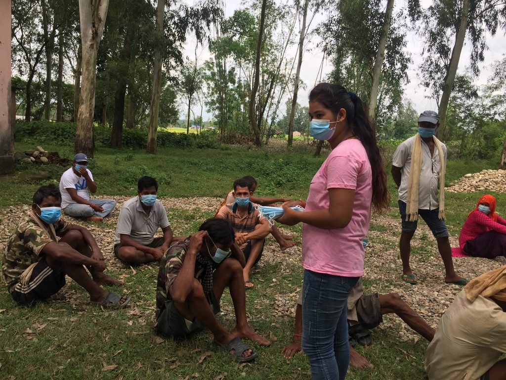 Samjhana distributing masks to people waiting to receive their COVID-19 vaccine