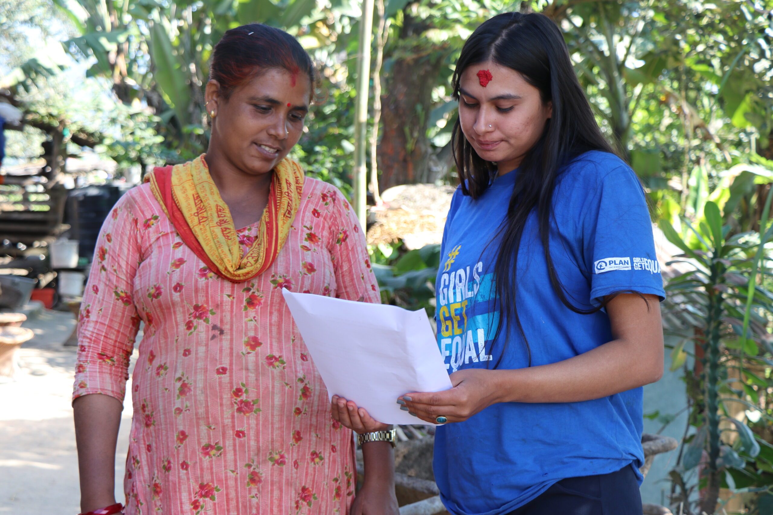 Rekha providing information on the COVID-19 vaccine schedule to a community member