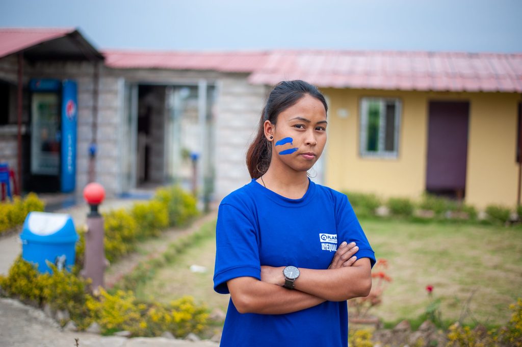 A girl from Nepal crossing her arms and looking at the camera