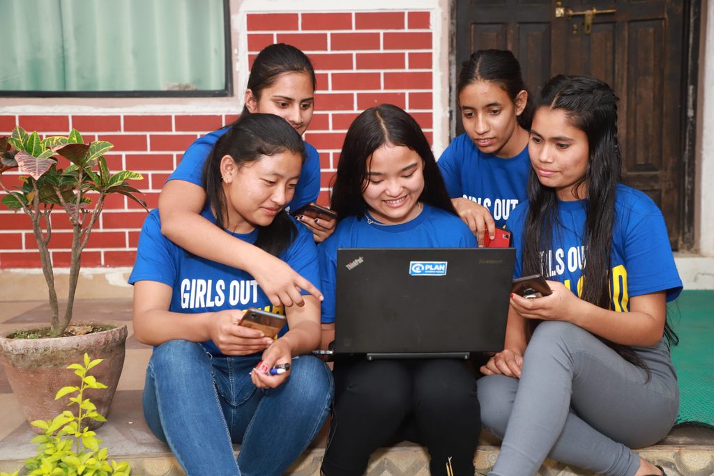 Girls looking at a laptop in Nepal