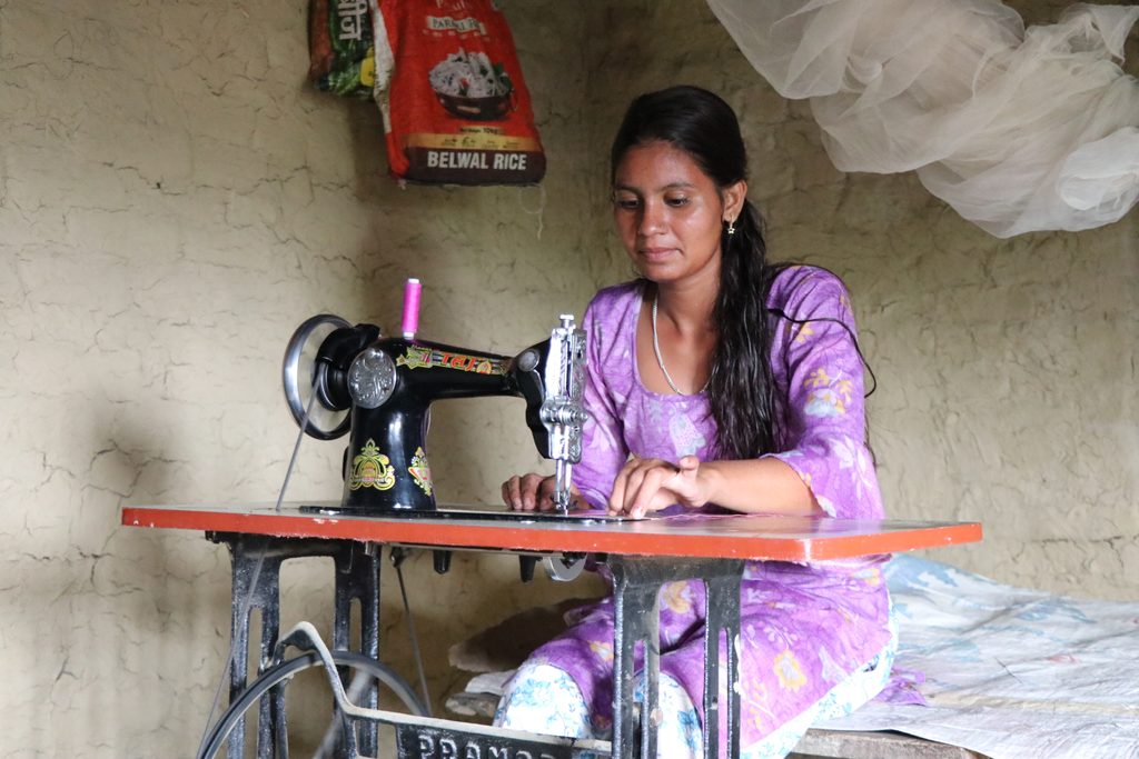 Parbati using a sewing machine to make clothing