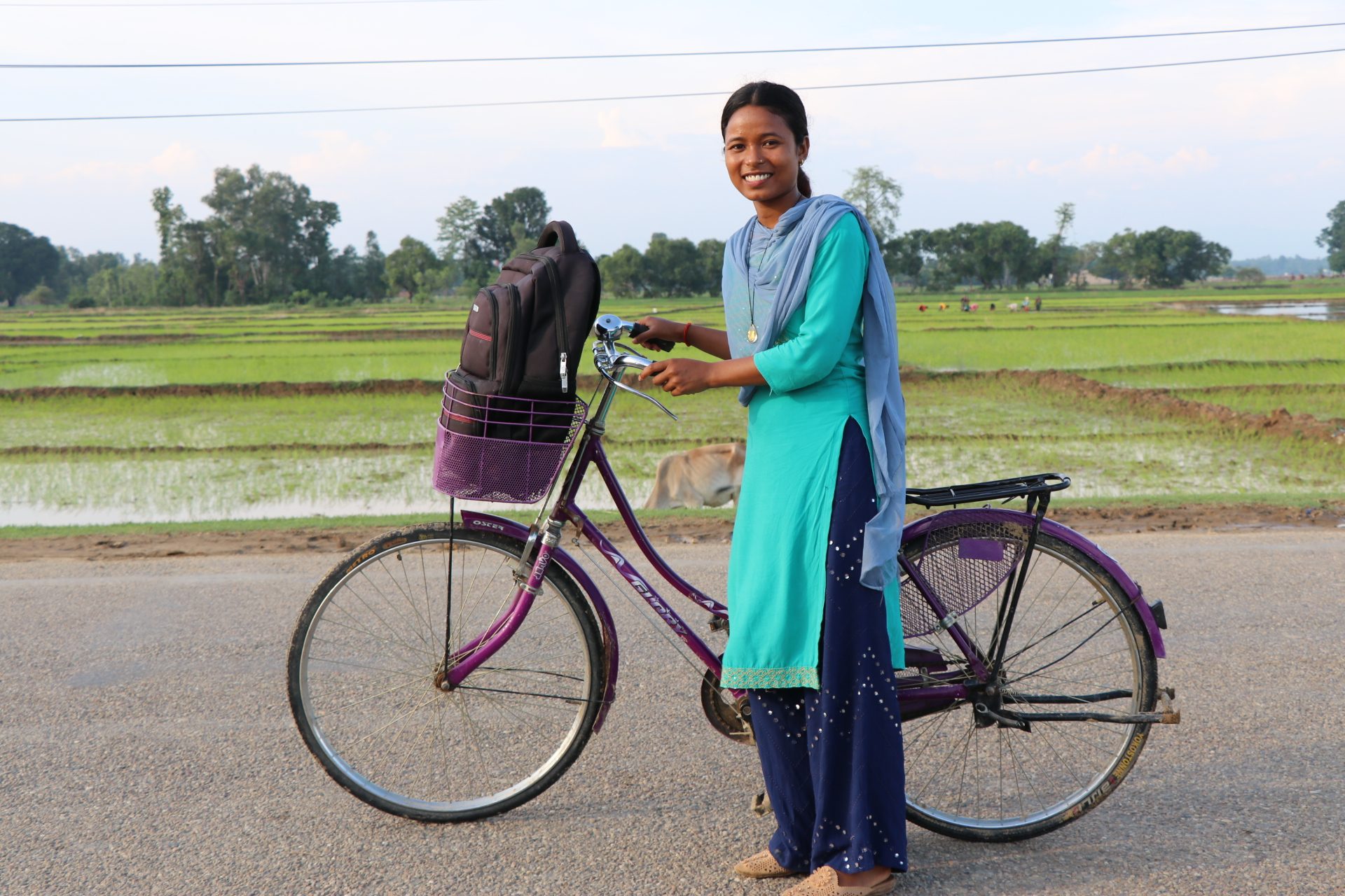 Asha travels around her community on her bicycle