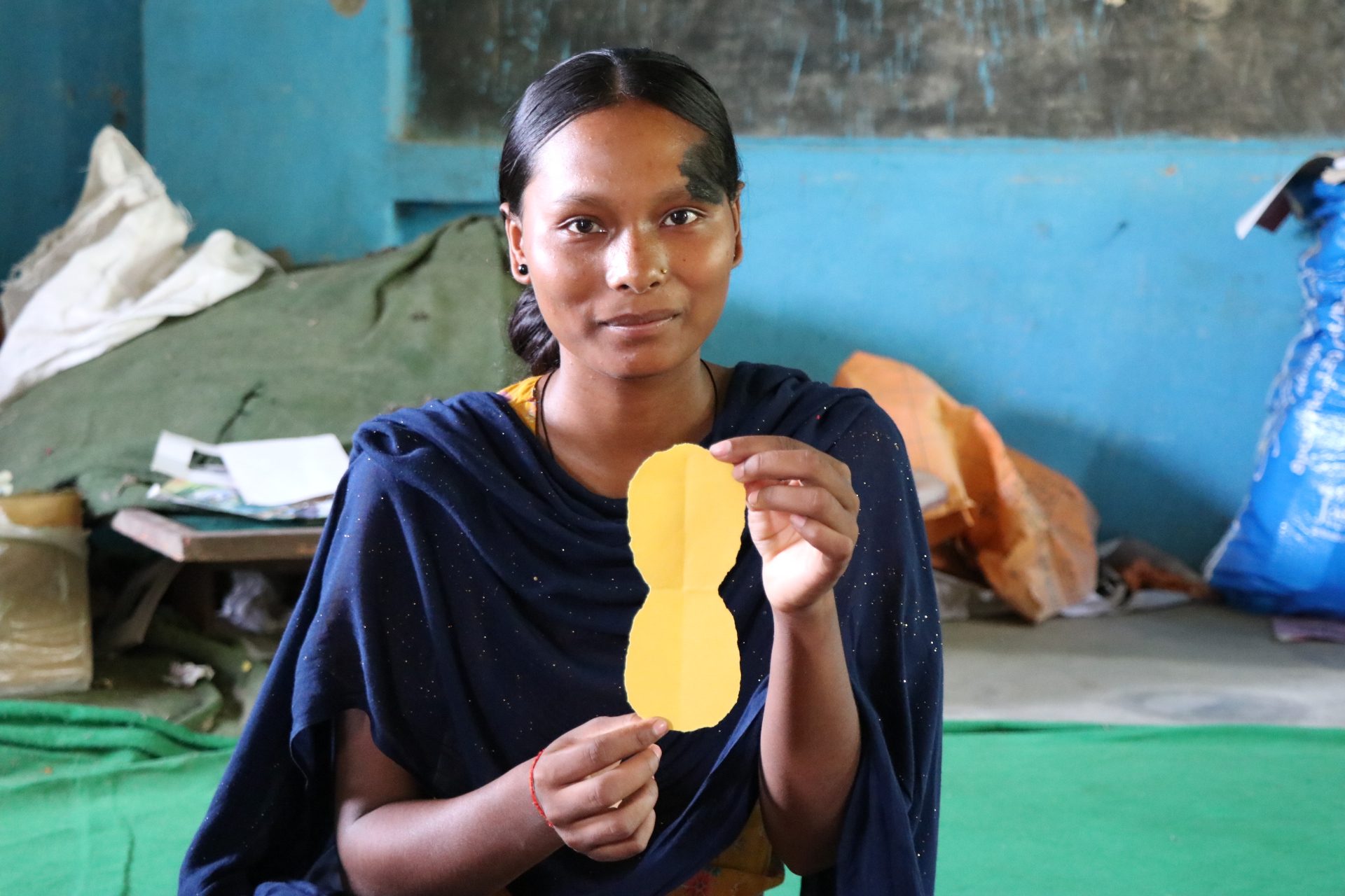 Radhika holding a mock sample of a sanitary pad