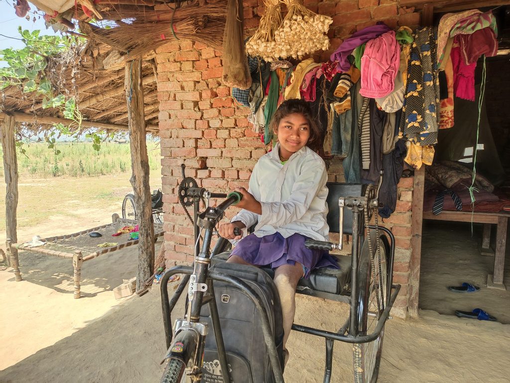 Saraswoti getting ready for school in her tricycle