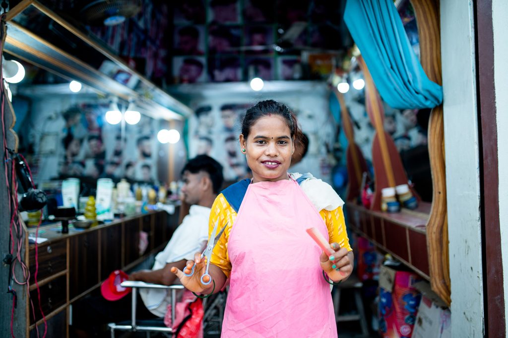 Rampati in her salon holding her comb and scissors.