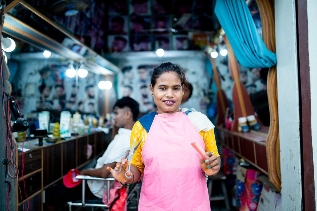 Rampati in her salon holding her comb and scissors. 