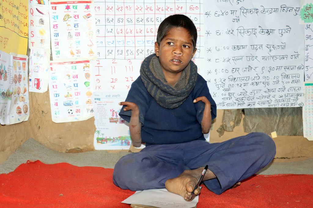 Bimal in his classroom decorated with reading materials.
