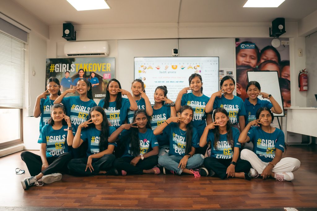 A group of girls wearing Girls Get Equal t-shirts and posing with the equal sign.