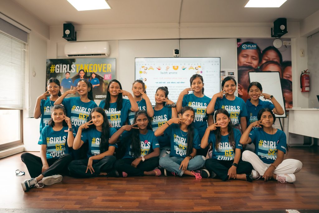 A group of girls wearing Girls Get Equal t-shirts and posing with the equal sign. 