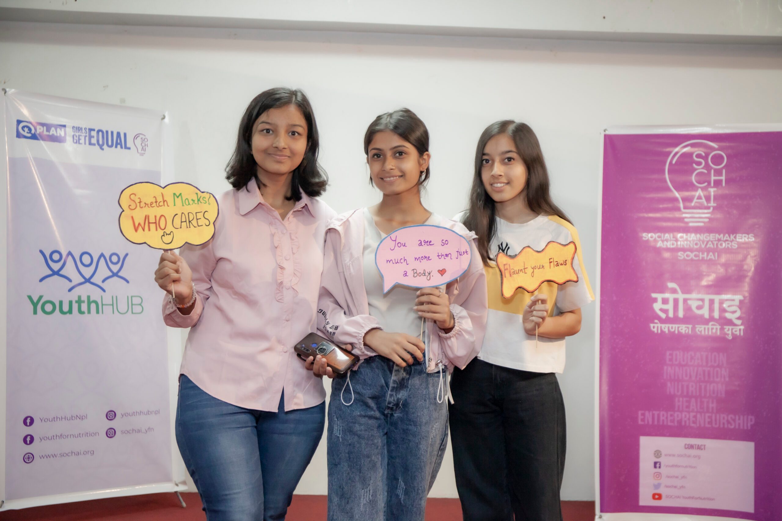 There girls holding placards on body positivity messages. 