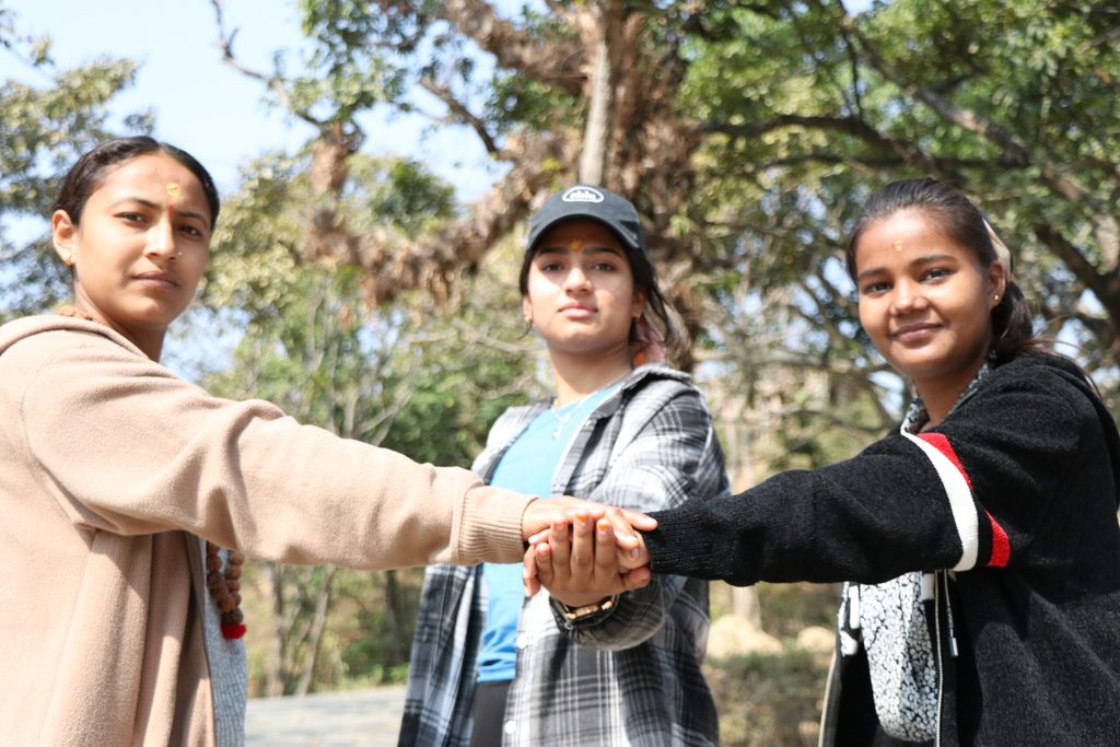 Three youth reporters posing after completing mobile journalism training.