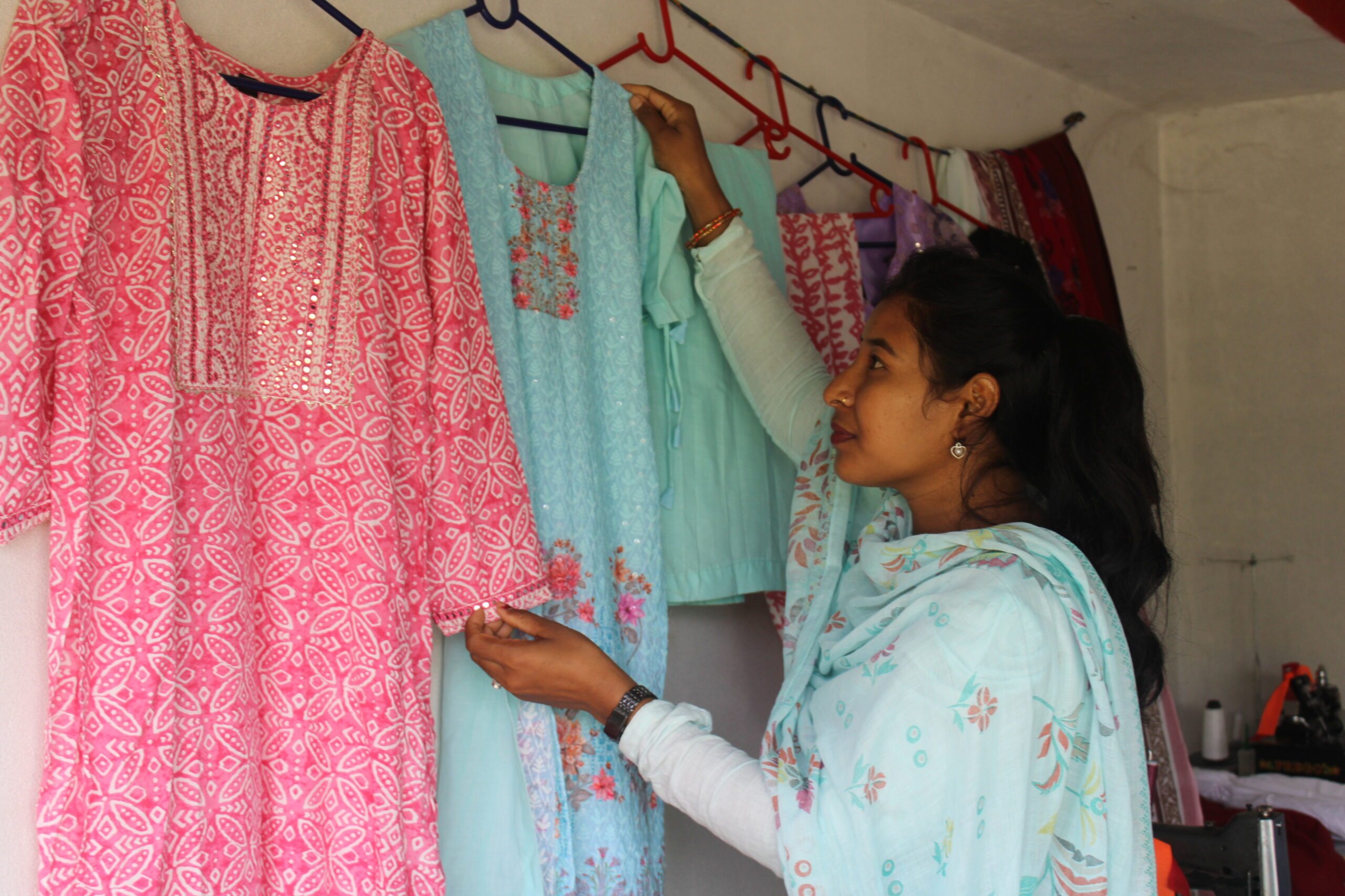 Rishmani arranging dresses in her shop.