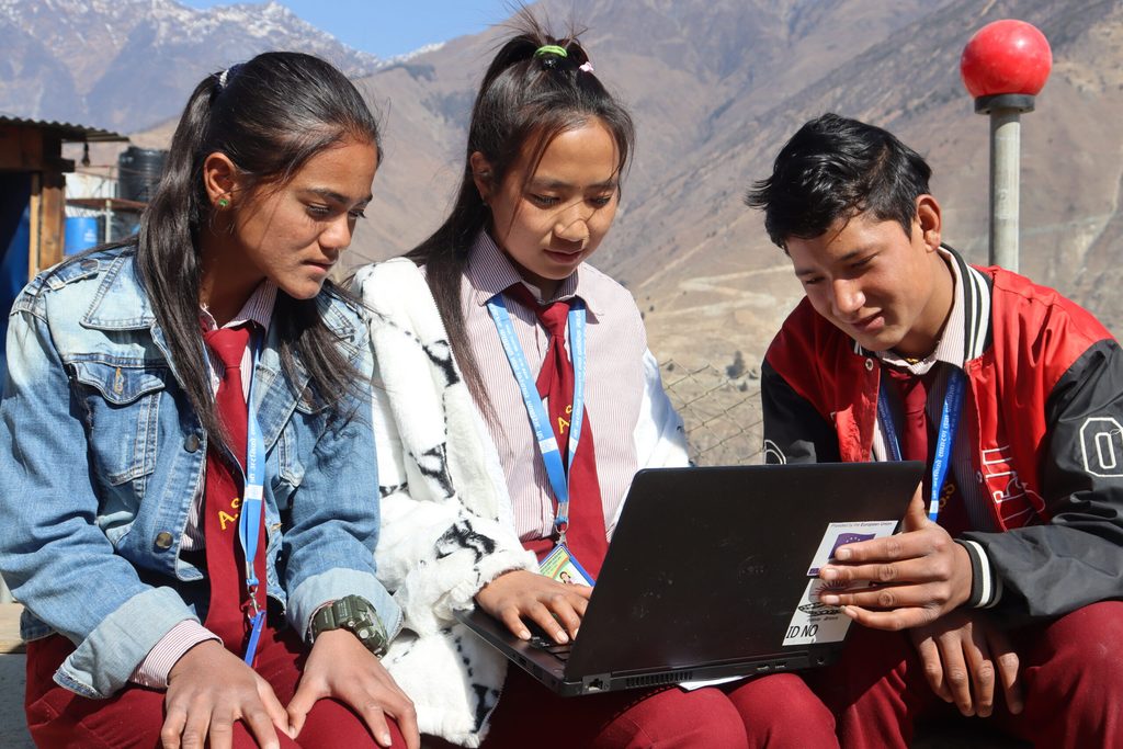 Prima and her friends working on a laptop.