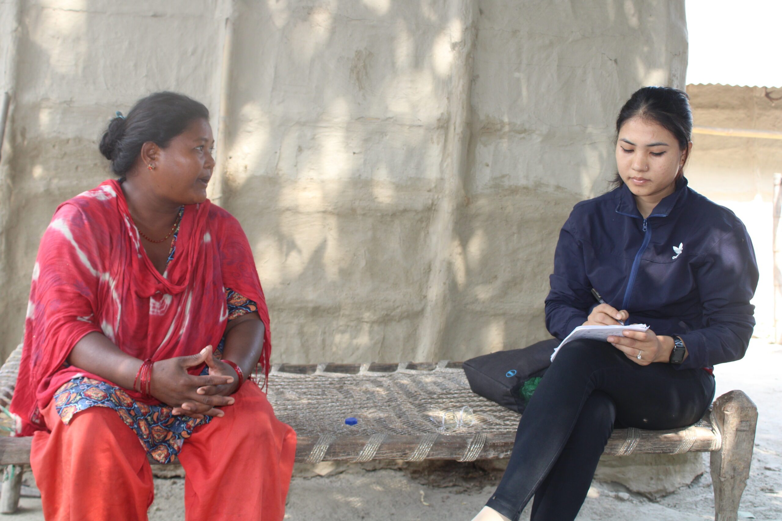 Gulfi and a BEE-Group employee sitting on a bench discussing education. 