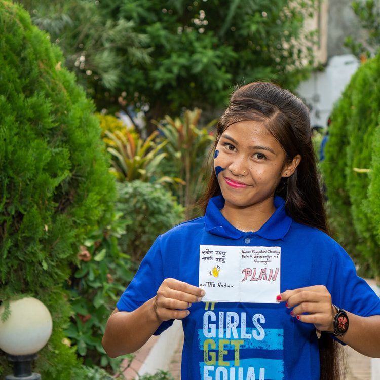 Sanjivani holding a paper and showing the content she made during training.