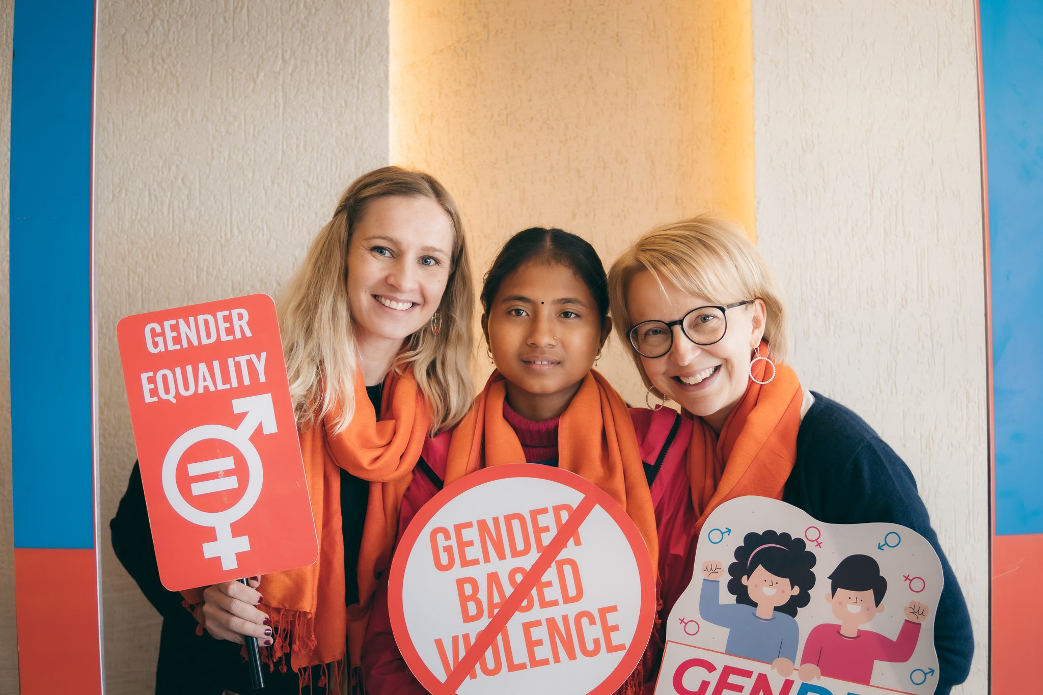 Three women holding placard on ending gender based violence.