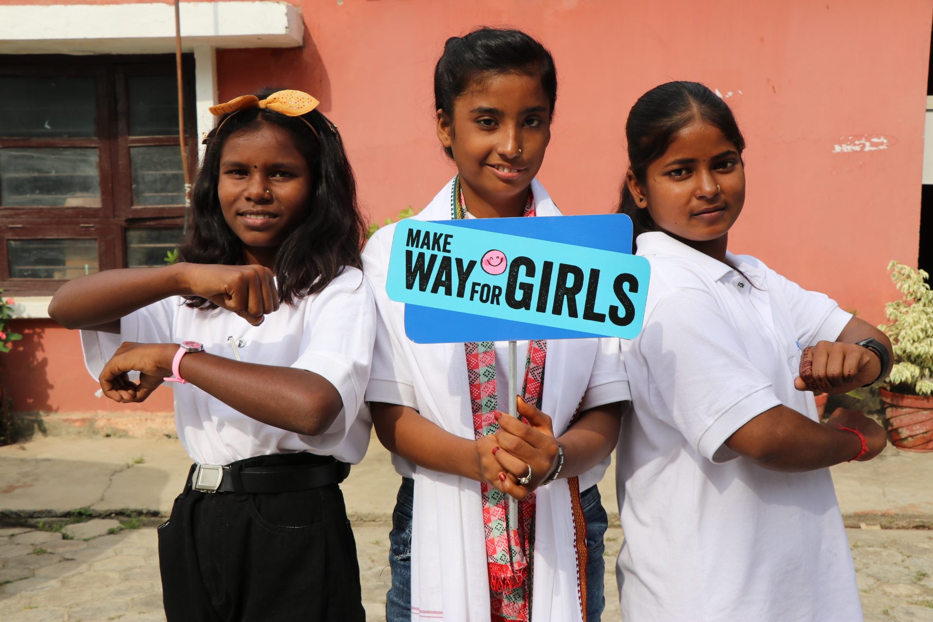 Rajina in the middle holding a placard "Make way for girls."